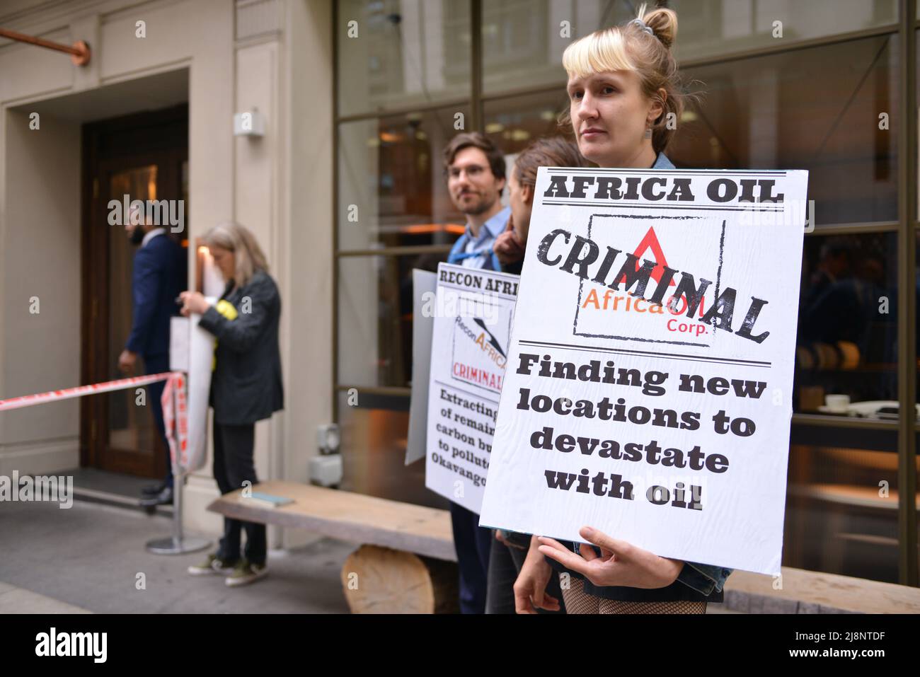Aktivisten halten während des Protestes Plakate mit Slogans, die ihre Meinung zum Ausdruck bringen, vor dem May Fair Hotel. Aktivisten des Extinction Rebellion stürmen das May Fair Hotel im Zentrum von London aus Protest gegen einen Ölgipfel (Africa Energies Summit), der im fünf-Sterne-Hotel stattfindet. Stockfoto