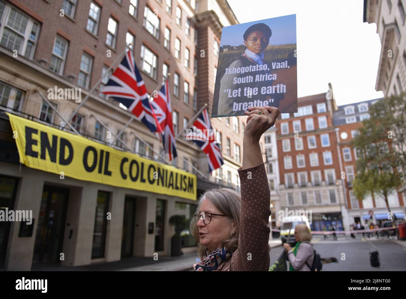 Aktivisten halten während des Protestes Plakate mit Slogans, die ihre Meinung zum Ausdruck bringen, vor dem May Fair Hotel. Aktivisten des Extinction Rebellion stürmen das May Fair Hotel im Zentrum von London aus Protest gegen einen Ölgipfel (Africa Energies Summit), der im fünf-Sterne-Hotel stattfindet. Stockfoto