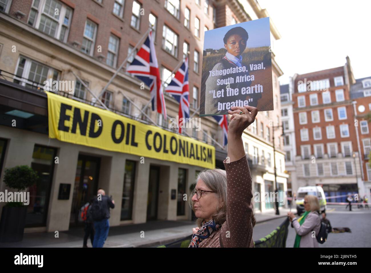 Aktivisten halten während des Protestes Plakate mit Slogans, die ihre Meinung zum Ausdruck bringen, vor dem May Fair Hotel. Aktivisten des Extinction Rebellion stürmen das May Fair Hotel im Zentrum von London aus Protest gegen einen Ölgipfel (Africa Energies Summit), der im fünf-Sterne-Hotel stattfindet. Stockfoto