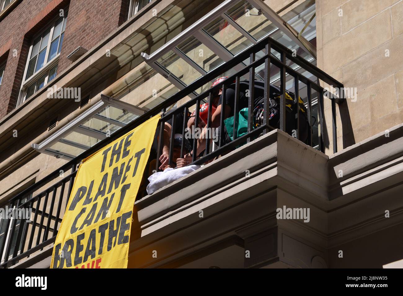 Die Polizisten lösen den Leim aus den Händen der Aktivisten auf dem Balkon des May Fair Hotels. Aktivisten des Extinction Rebellion stürmen das May Fair Hotel im Zentrum von London aus Protest gegen einen Ölgipfel (Africa Energies Summit), der im fünf-Sterne-Hotel stattfindet. Stockfoto