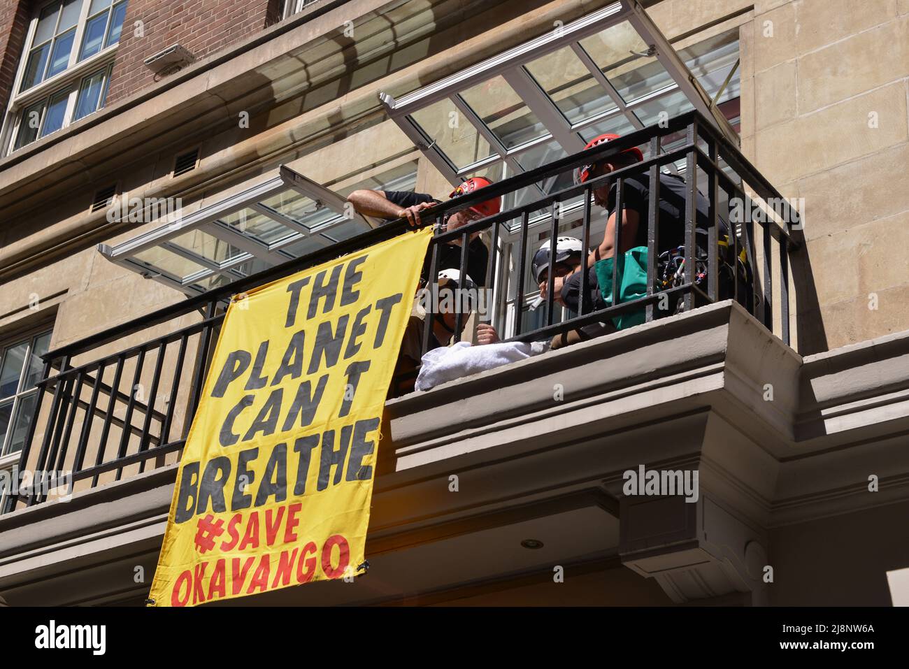 Die Polizisten lösen den Leim aus den Händen der Aktivisten auf dem Balkon des May Fair Hotels. Aktivisten des Extinction Rebellion stürmen das May Fair Hotel im Zentrum von London aus Protest gegen einen Ölgipfel (Africa Energies Summit), der im fünf-Sterne-Hotel stattfindet. Stockfoto