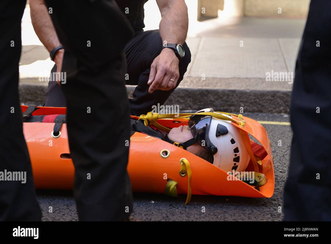 Ein festgenommener Aktivist wird von der Polizei auf einer Bahre getragen, nachdem er vom Balkon des May Fair Hotels entfernt wurde. Aktivisten des Extinction Rebellion stürmen das May Fair Hotel im Zentrum von London aus Protest gegen einen Ölgipfel (Africa Energies Summit), der im fünf-Sterne-Hotel stattfindet. Stockfoto