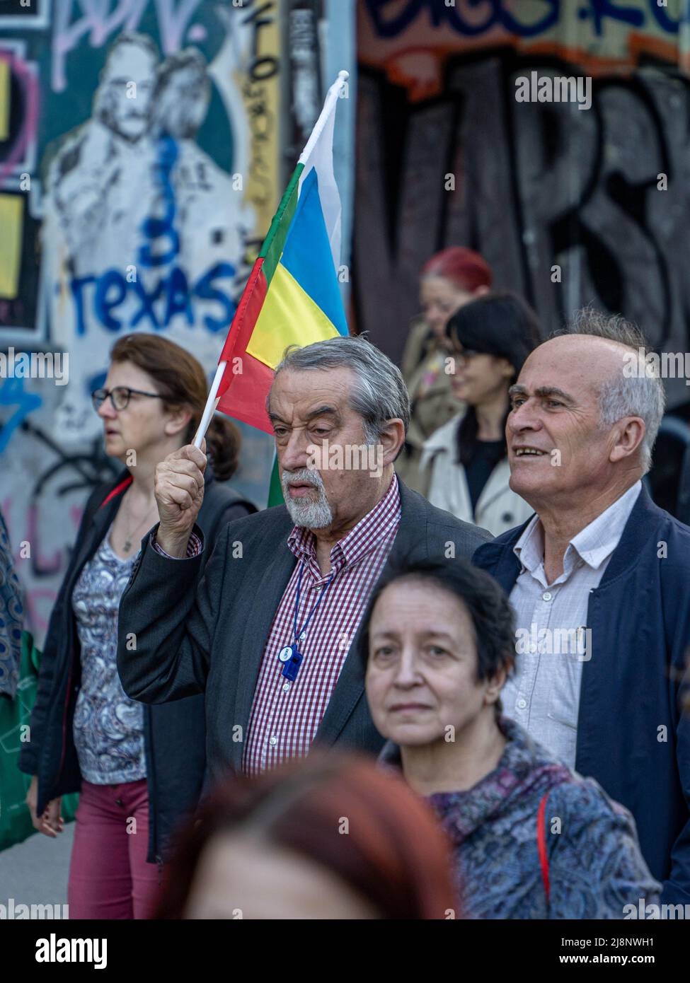 Sofia, Bulgarien - 09. Mai 2022: Zwei reife Männer, von denen einer bulgarische und ukrainische Flaggen in der Hand hält, gehen in einer Menschenmenge Stockfoto