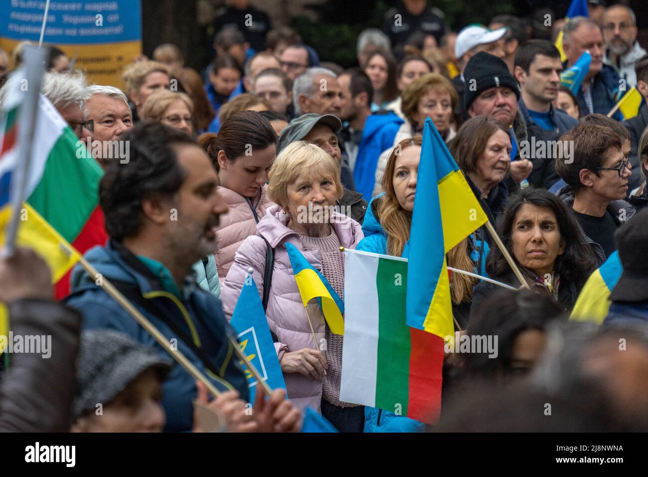 Beim Help Ukraine march in Sofia, Bulgarien, steht eine reife Frau mit ukrainischer Flagge in einer Menschenmenge Stockfoto