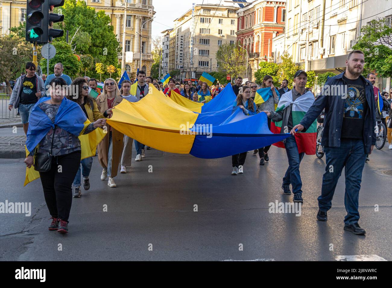 Eine Säule von Männern und Frauen geht mit einer riesigen Flagge der Ukraine in ihren Händen bei der pro-ukrainischen Demonstration Support Ukraine Stockfoto