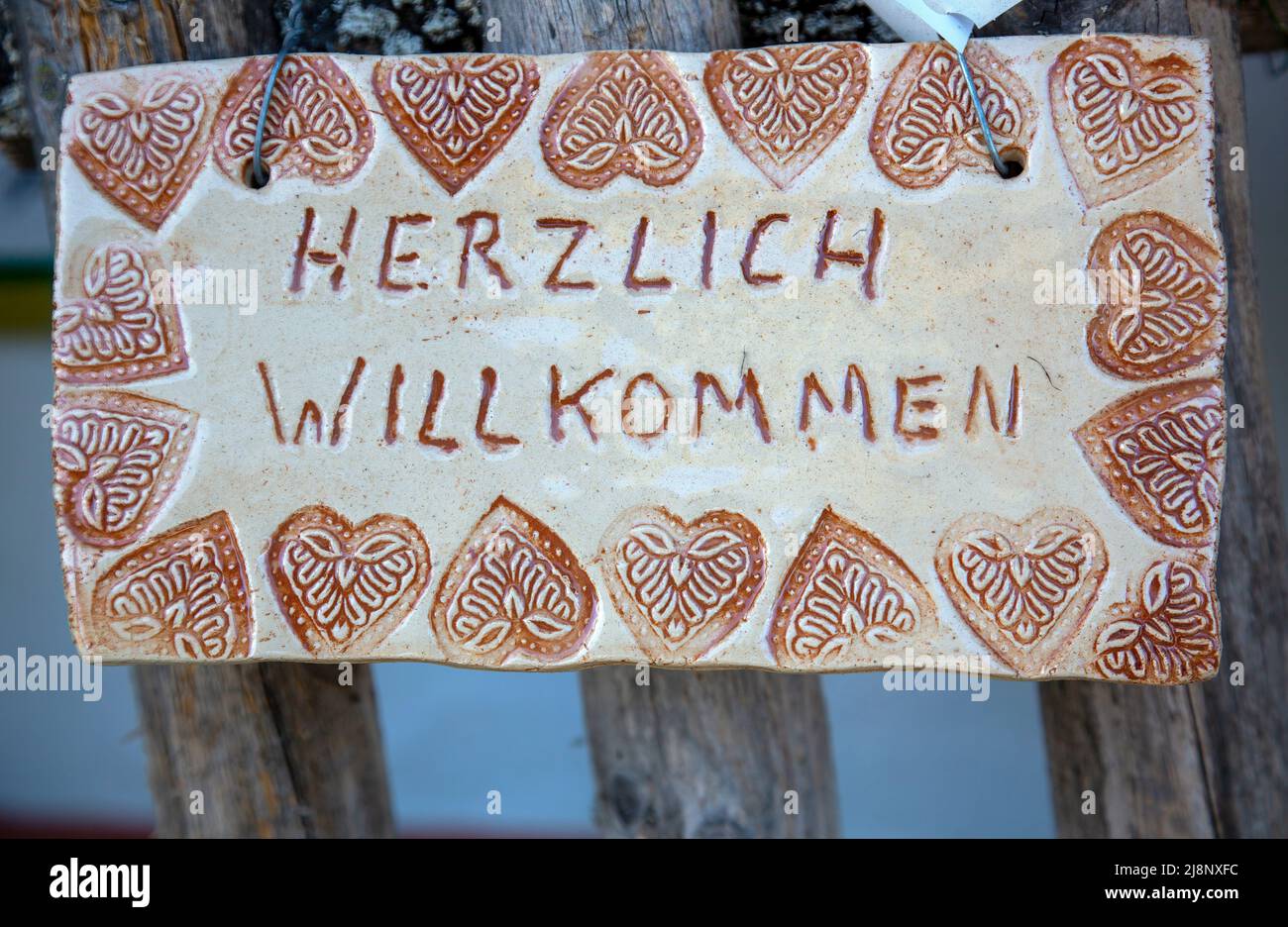 Selbstgebasteltes Schild mit der Schrift 'Herzlich willkommen' in