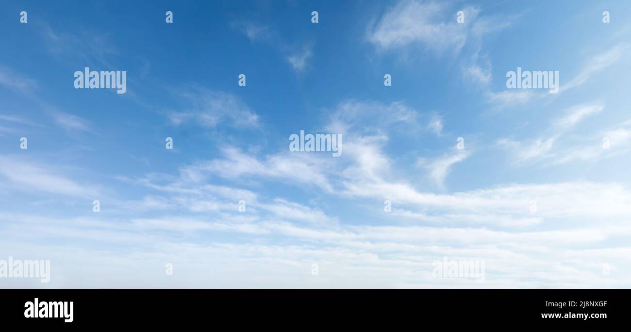 Weitwinkelfoto des sonnigen und windigen Wetterhimmels mit Blautönen. Sommer- oder Frühlingshimmel mit Wolkenlandschaft. Stockfoto