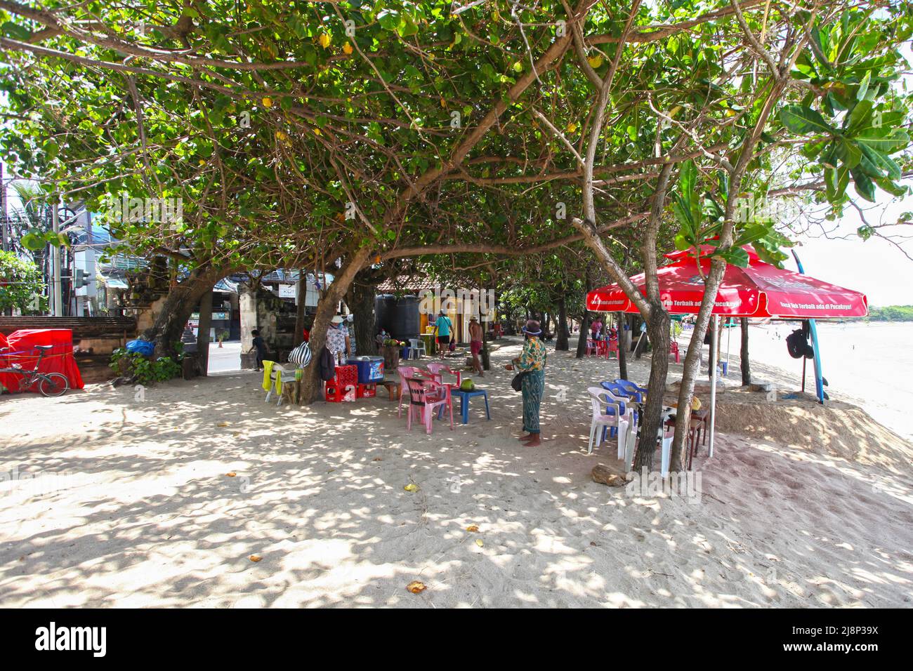 Kuta Beach Szene in Bali, Indonesien im März 2022 während der Pandemie mit wenigen Touristen, Getränkeverkäufern, Sonnenschirmen und einem ruhigen Strand. Stockfoto