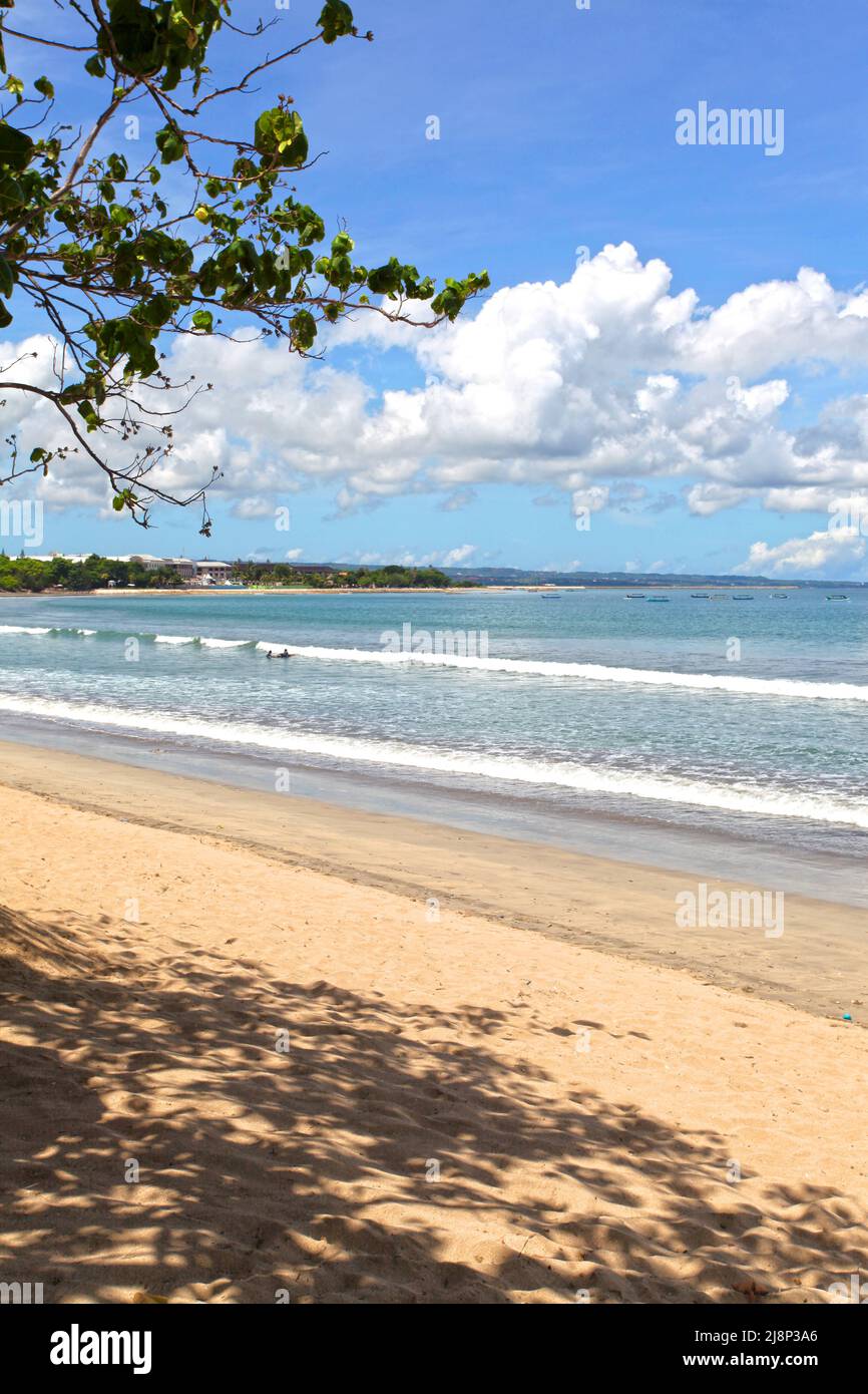 Kuta Beach Szene in Bali, Indonesien im März 2022 während der Pandemie mit wenigen Touristen, Getränkeverkäufern, Sonnenschirmen und einem ruhigen Strand. Stockfoto