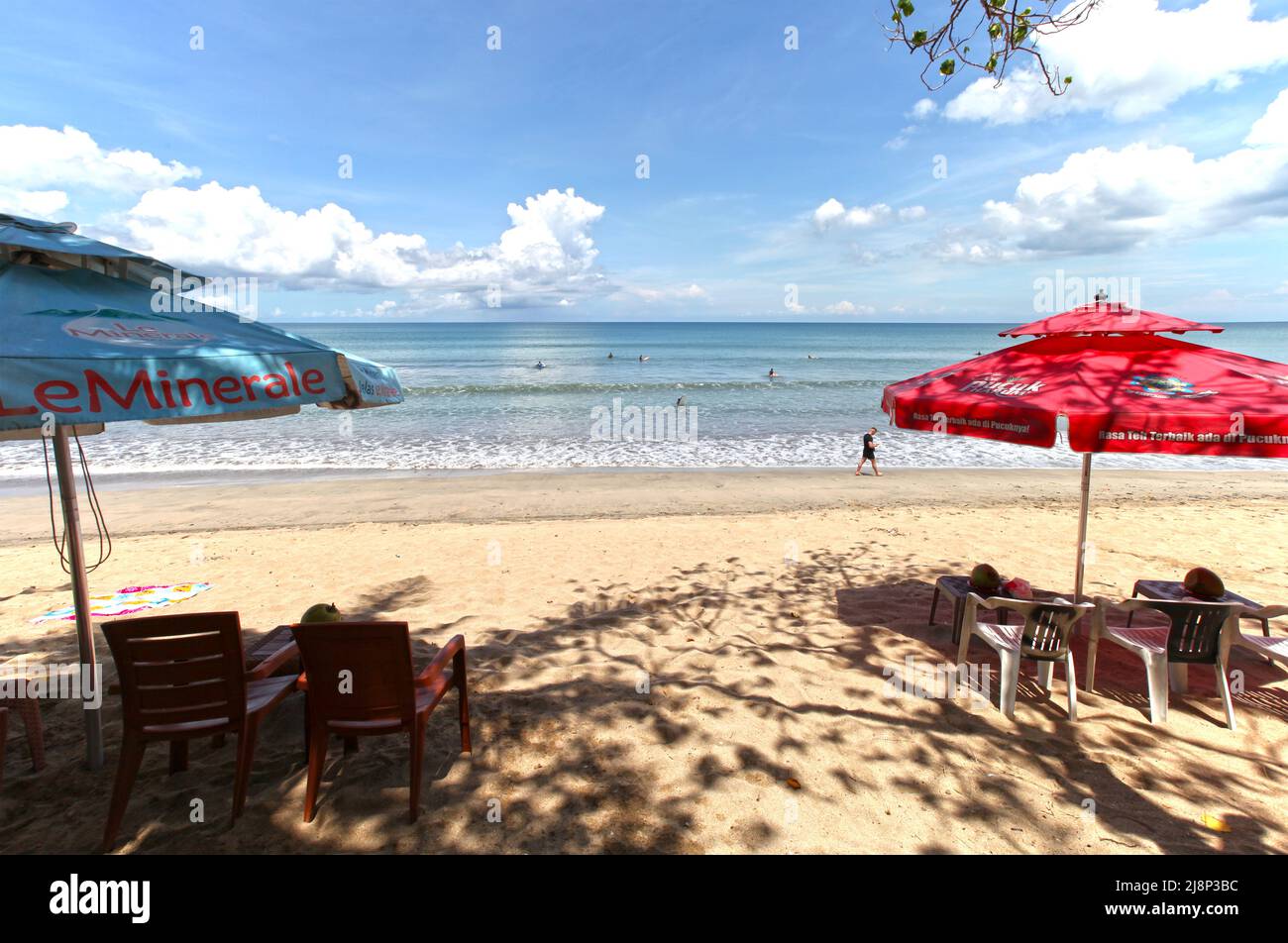Kuta Beach Szene in Bali, Indonesien im März 2022 während der Pandemie mit wenigen Touristen, Getränkeverkäufern, Sonnenschirmen und einem ruhigen Strand. Stockfoto