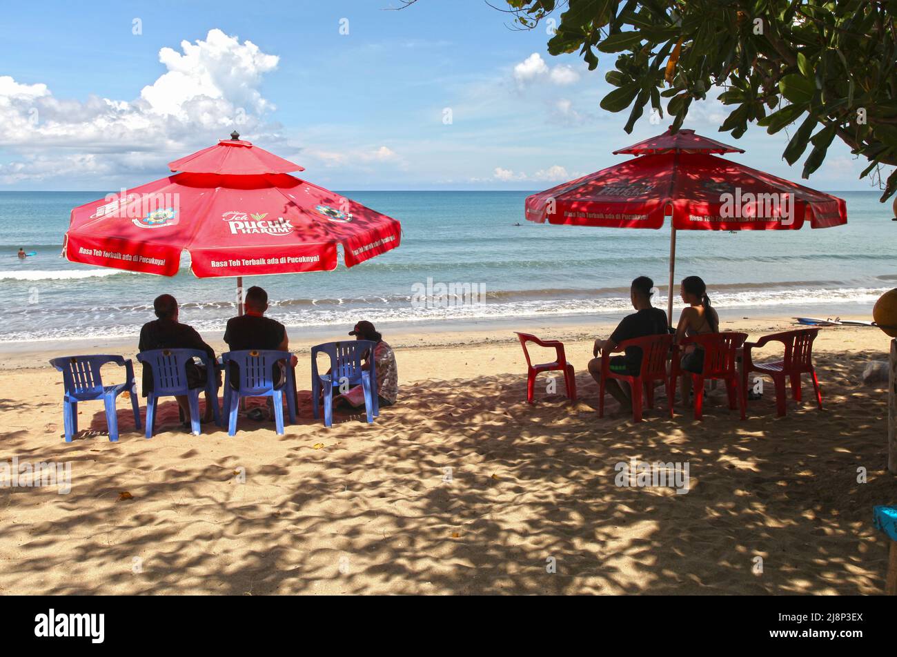 Kuta Beach Szene in Bali, Indonesien im März 2022 während der Pandemie mit wenigen Touristen, Getränkeverkäufern, Sonnenschirmen und einem ruhigen Strand. Stockfoto