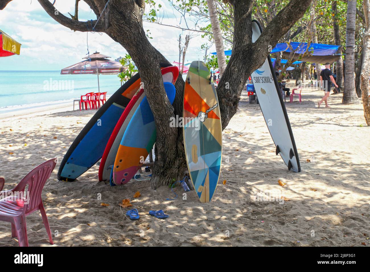 Kuta Beach Szene in Bali, Indonesien im März 2022 während der Pandemie mit wenigen Touristen, Getränkeverkäufern, Sonnenschirmen und einem ruhigen Strand. Stockfoto