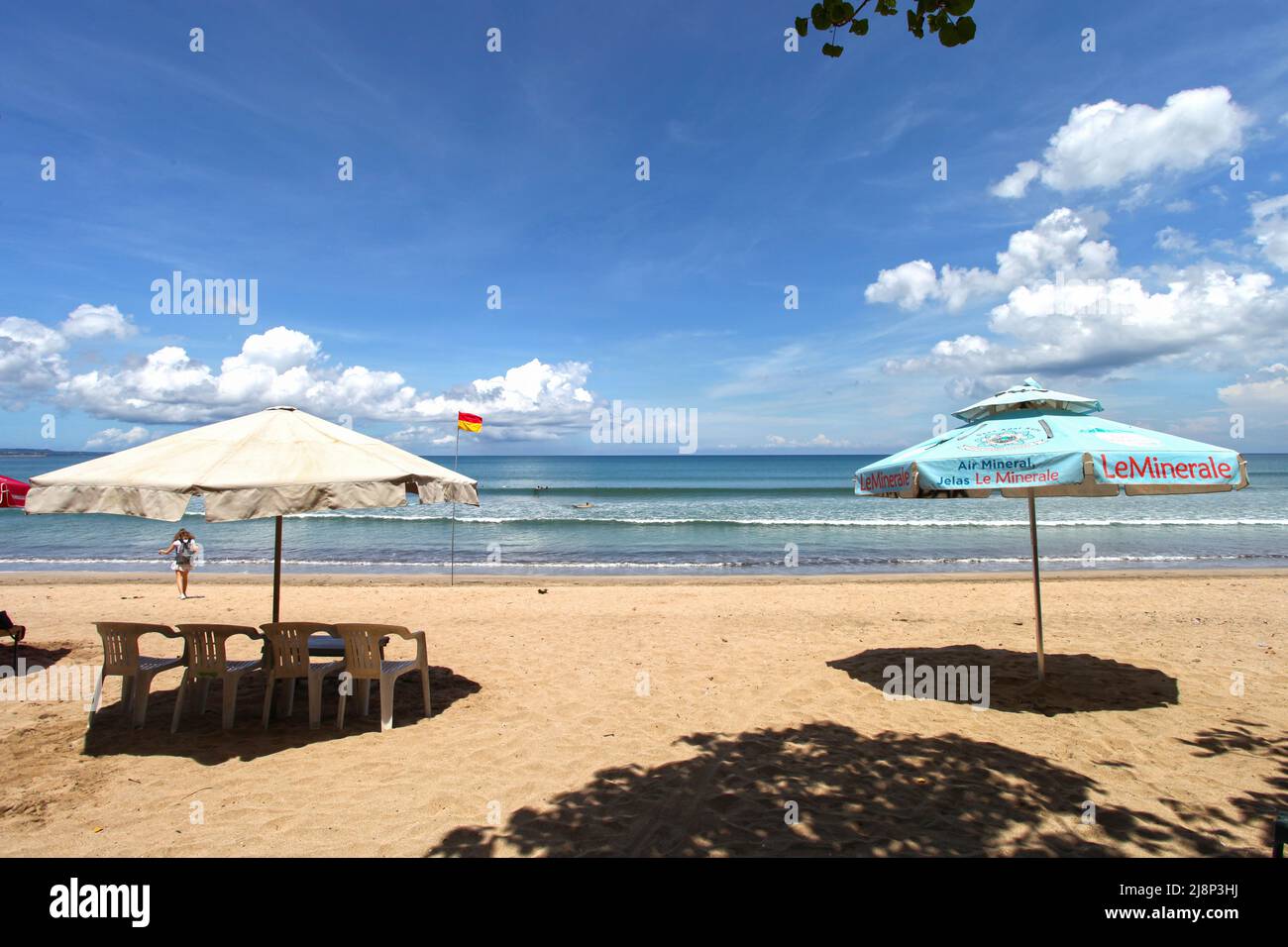 Kuta Beach Szene in Bali, Indonesien im März 2022 während der Pandemie mit wenigen Touristen, Getränkeverkäufern, Sonnenschirmen und einem ruhigen Strand. Stockfoto