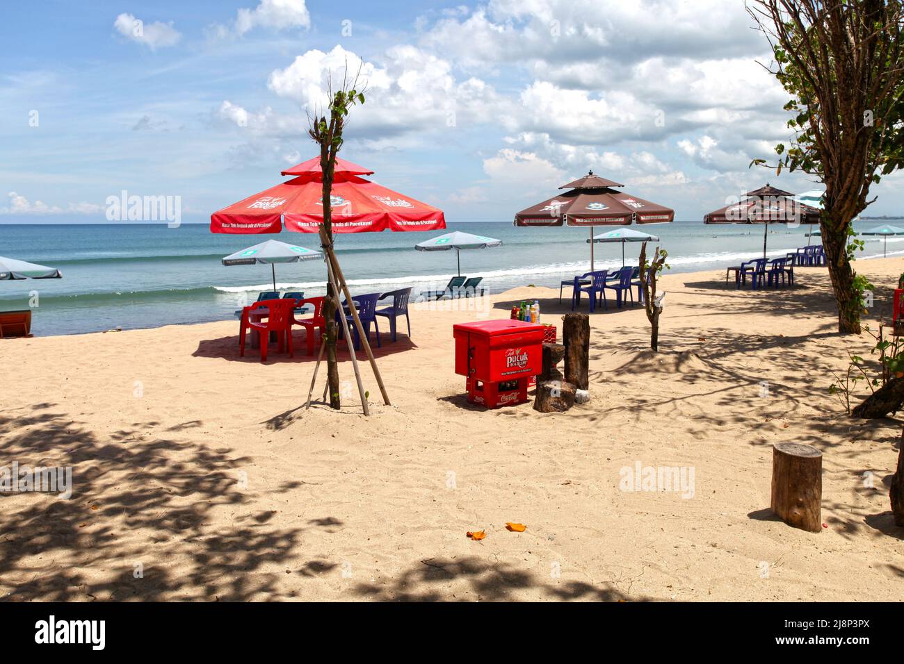 Kuta Beach Szene in Bali, Indonesien im März 2022 während der Pandemie mit wenigen Touristen, Getränkeverkäufern, Sonnenschirmen und einem ruhigen Strand. Stockfoto