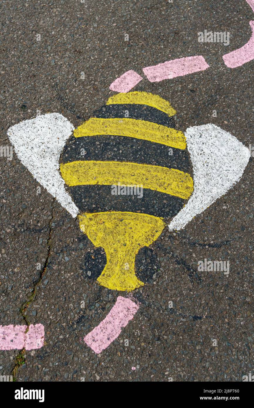 Kreidebemalte Biene und gepunkteter Pfad auf Asphalt Stockfoto