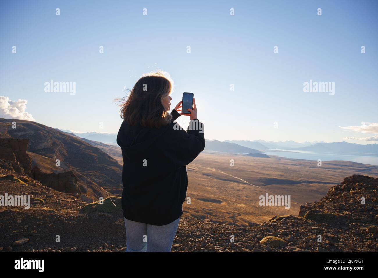 Das Mädchen macht Fotos auf dem Handy Blick auf das Bergtal Stockfoto