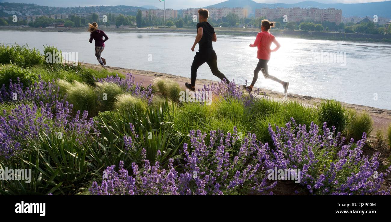 Riverside Park in der Stadt. Drei junge Menschen beim Laufen Stockfoto