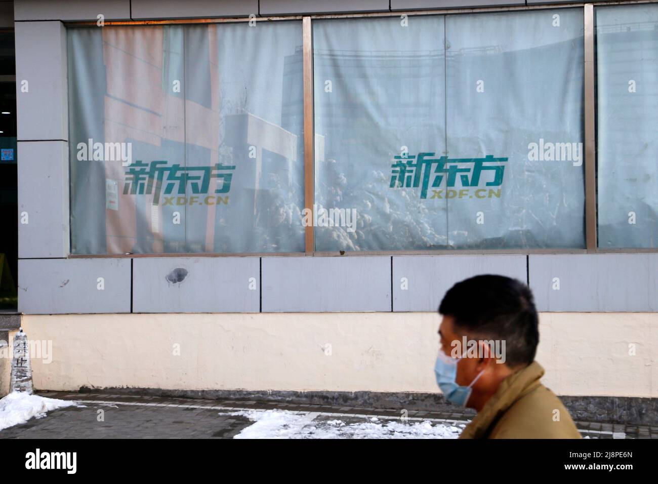 PEKING, CHINA - 19. MÄRZ 2022 - Ein Bürger kommt am 19. März 2022 in Peking, China, an der Neuen Orientalischen Schule vorbei. Stockfoto