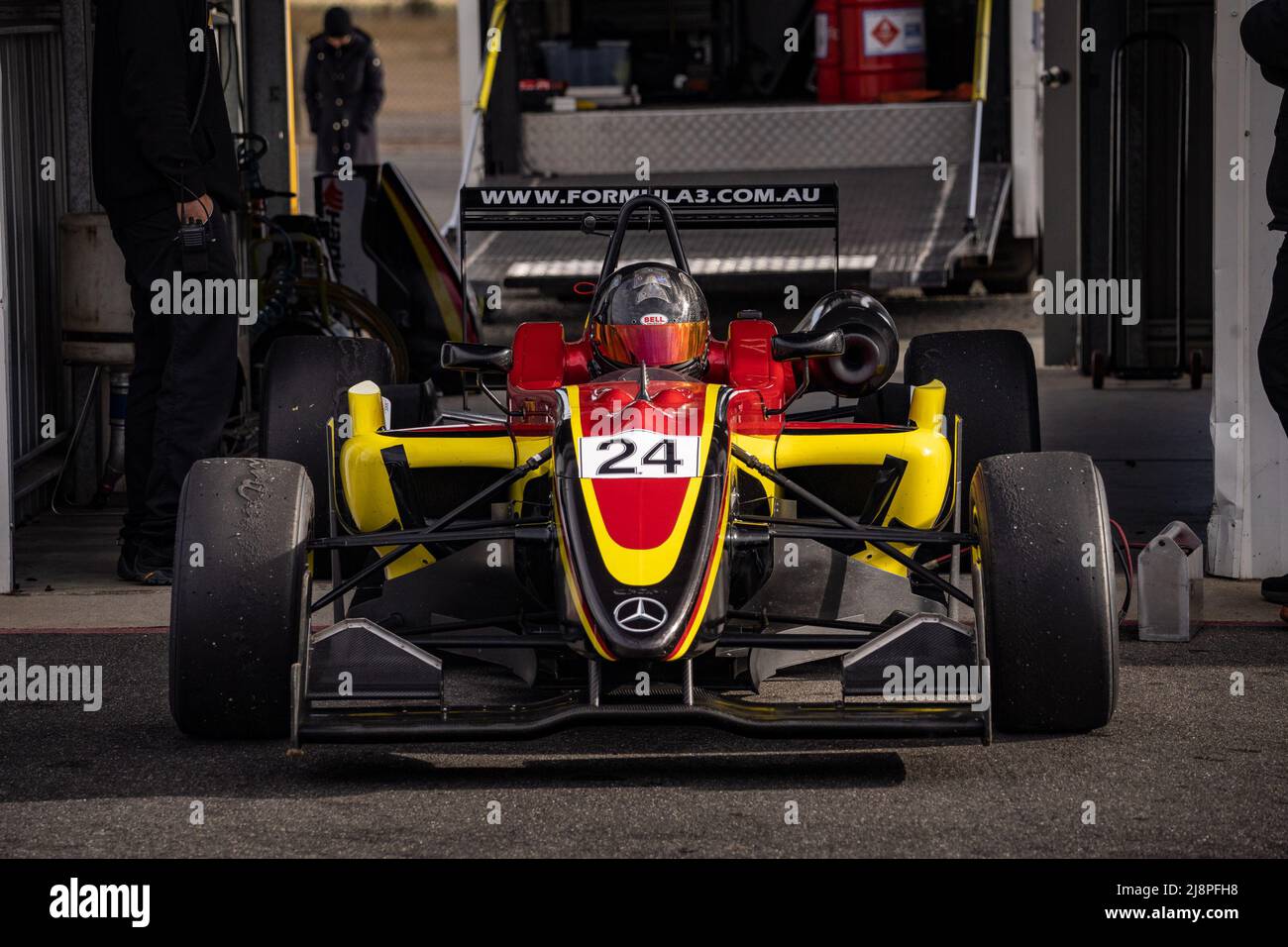 Die gelbe und rote Nummer 24 Australien Formel 3 Auto sitzt in der Pitlane kurz vor dem Start zum Test auf Winton Motor Raceway. Stockfoto