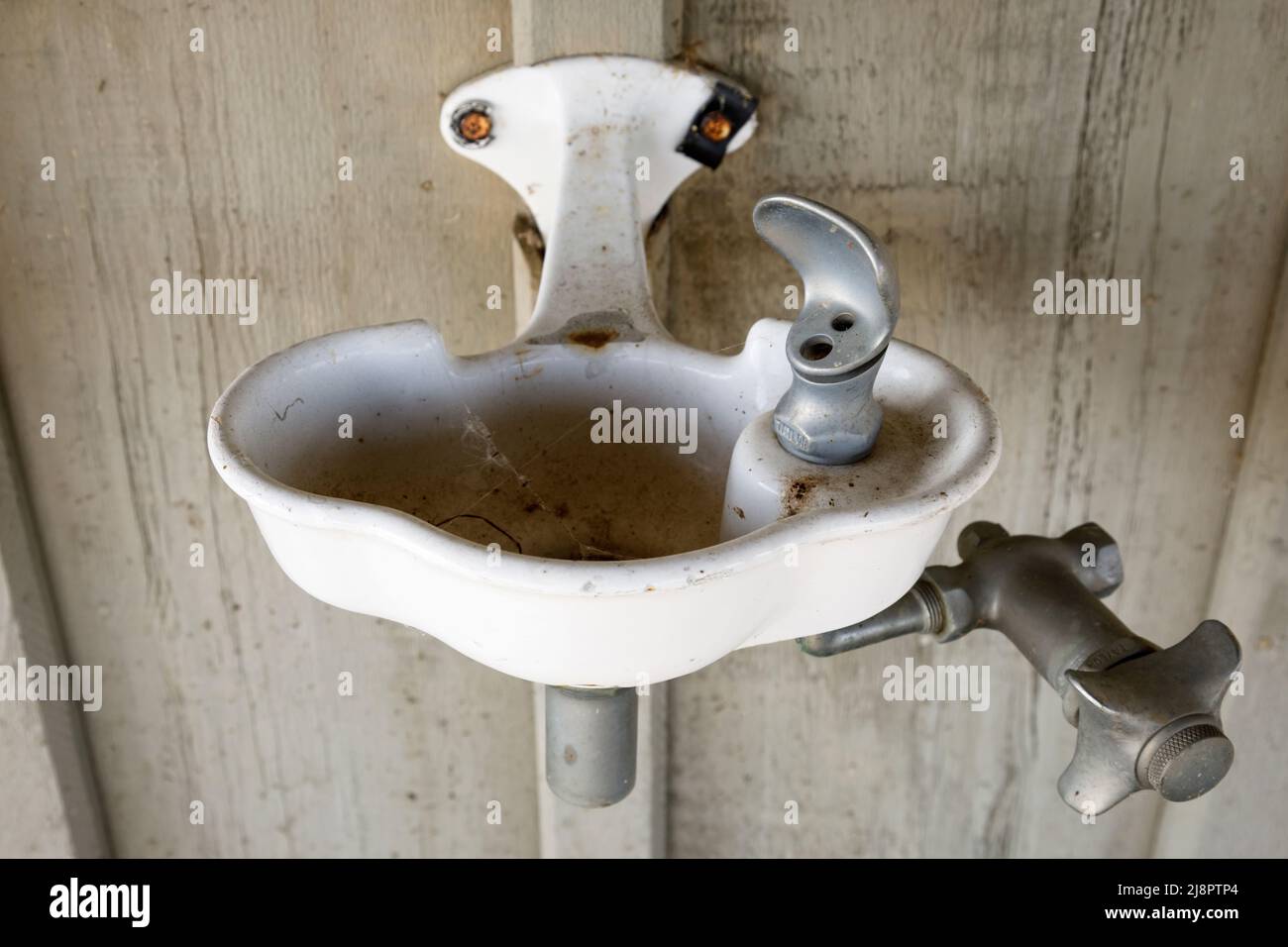 Ein alter Vintage Trinkbrunnen. Dieses Haus wurde seitdem abgerissen. Stockfoto