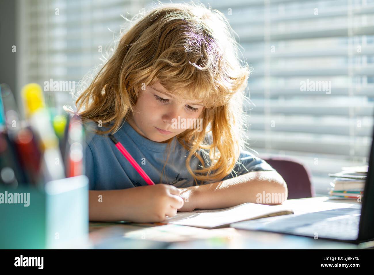 Kind schreibt in der Schule. Präteen Schuljunge tun ihre Hausaufgaben zu Hause. Kinderstudie. Bildung und Lernen für Kinder. Netter kleiner Junge, der Hausaufgaben macht Stockfoto