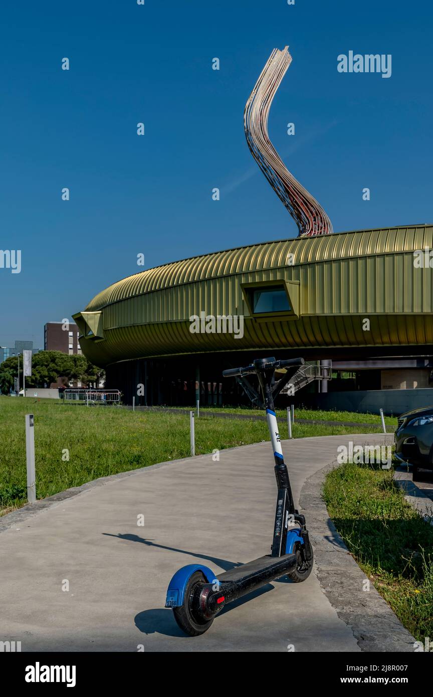Ein Elektroroller mit dem Luigi Pecci Zentrum für zeitgenössische Kunst im Hintergrund, Prato, Italien Stockfoto