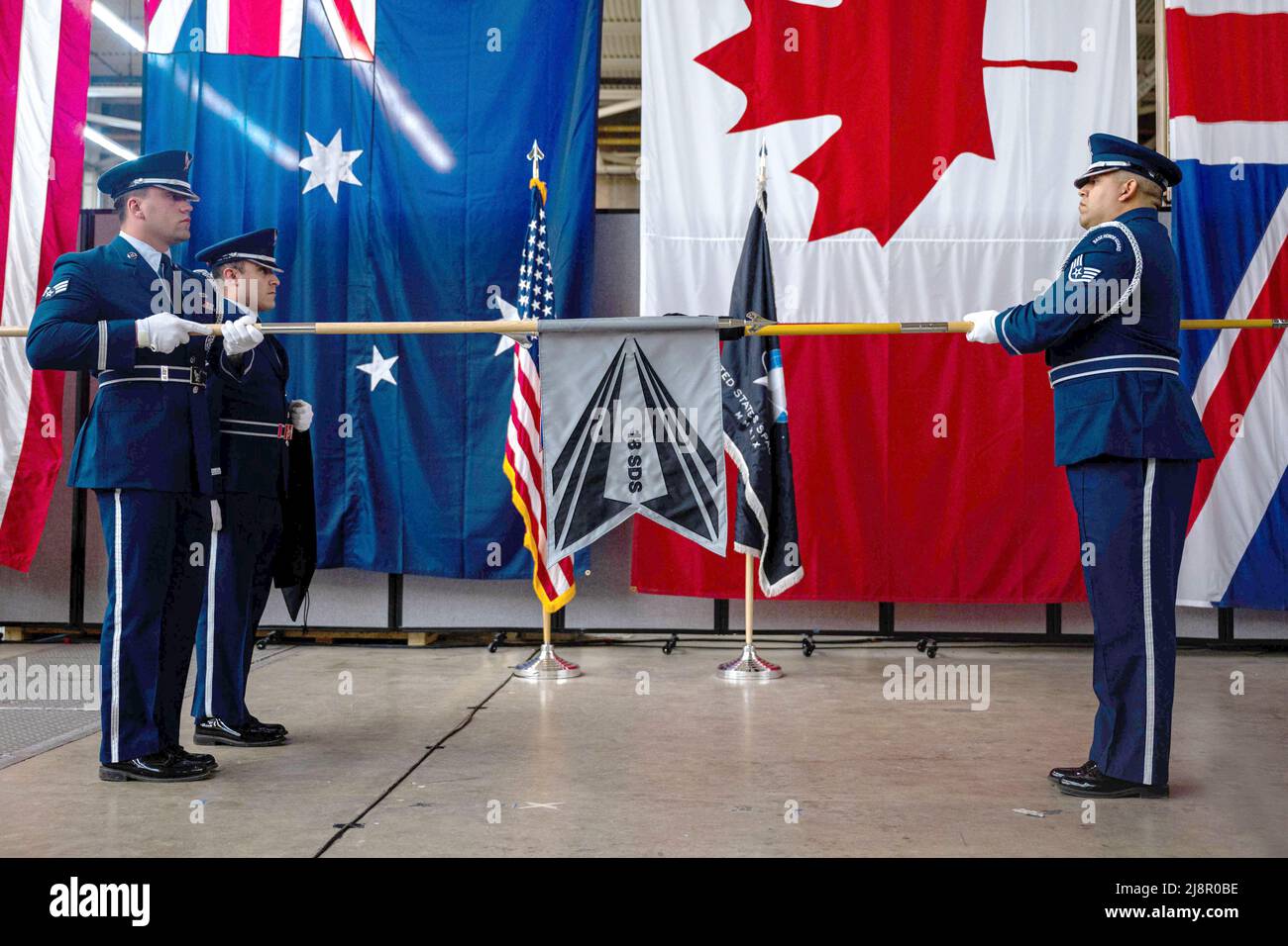 13. April 2022 - Vandenberg Space Force Base, California, USA - Mitglieder des Ehrengarderteams der Vandenberg Space Force Base entrollten die Flagge des neuen 18. Space Defense Squadron während einer Zeremonie zur Neubestimmung am Vandenberg SFB, Kalifornien, 13. April 2022. Das Space Control Squadron von 18. wurde als SDS von 18 neu benannt, um einen verstärkten Fokus auf die Führung und Kontrolle von Space Domain Awareness (SDA), die Integration und Synchronisierung von SDA-Fähigkeiten zur Unterstützung der umstrittenen und überlasteten Domäne sowie die Zusammenarbeit mit Verbündeten und Partnern zu signalisieren. Das Rollieren und Entrollen von Flaggen hat lange gedauert Stockfoto