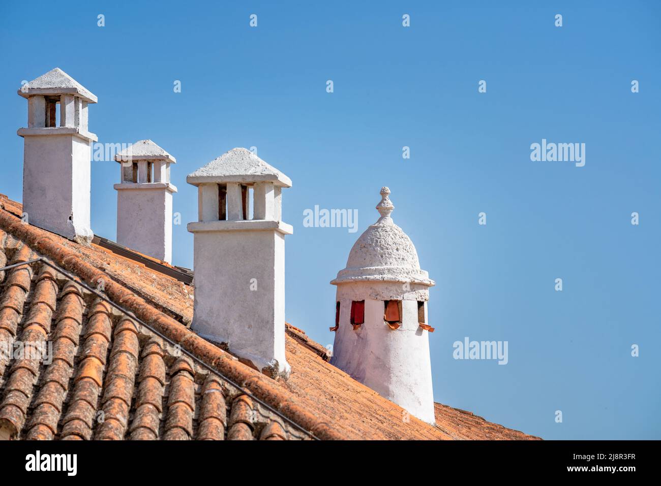 Traditionelle weiße Kamine über einer Dachziegel in Cáceres Spanien Stockfoto
