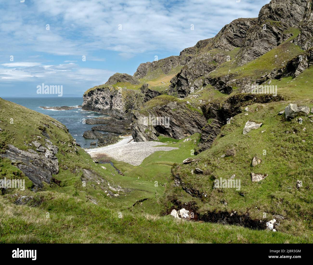 Klippen und Kiesstrand in Port Ban in der Nähe von Pigs Paradise auf der Hebriden-Insel Colonsay, Schottland, Großbritannien Stockfoto