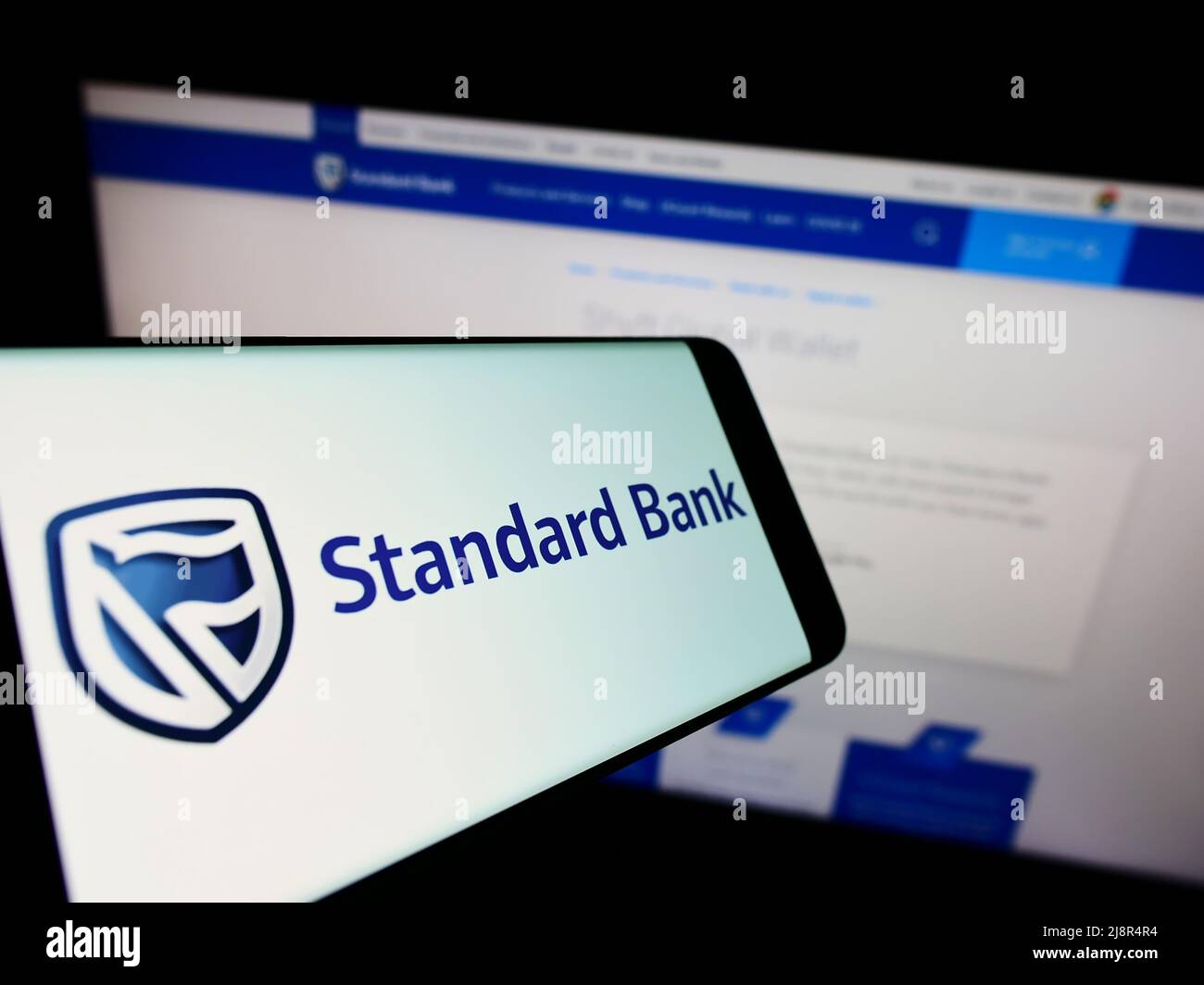 Smartphone mit Logo des südafrikanischen Unternehmens Standard Bank Group Limited auf dem Bildschirm vor der Website. Konzentrieren Sie sich auf die Mitte rechts des Telefondisplays. Stockfoto