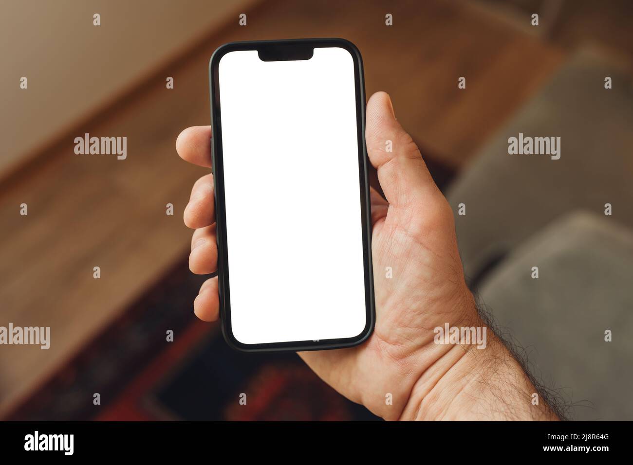 Smartphone-Mockup, Internet der Dinge und Smart-Home-Konzept, Mann mit Mobiltelefon. Nahaufnahme der Handhaltevorrichtung mit leerem Bildschirm im Home Interi Stockfoto