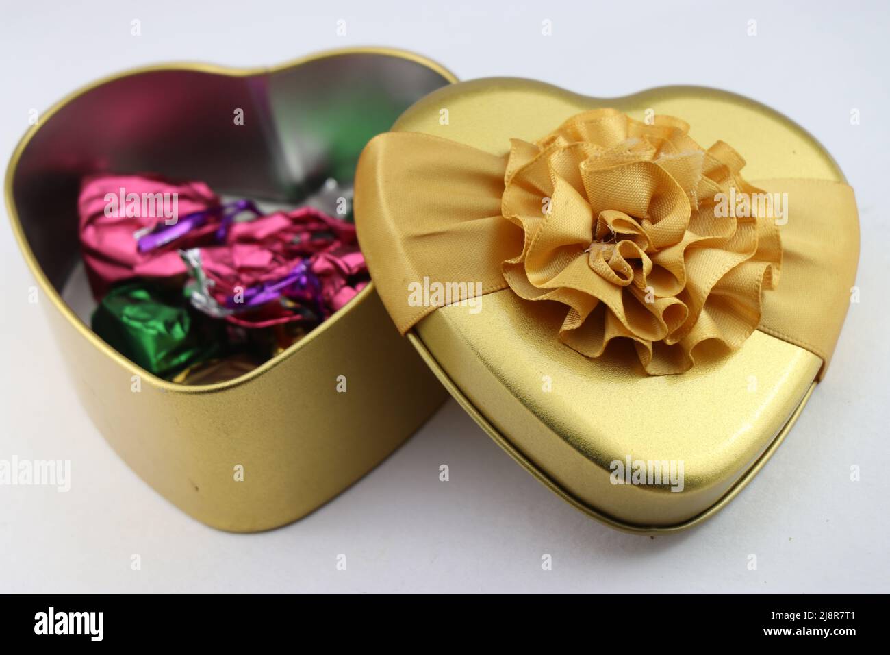 Herzförmige Geschenkschachtel mit Pralinen innen auf weißem Hintergrund, Geschenkschachteln für Geburtstage, Valentinstag und andere besondere Veranstaltungen Stockfoto