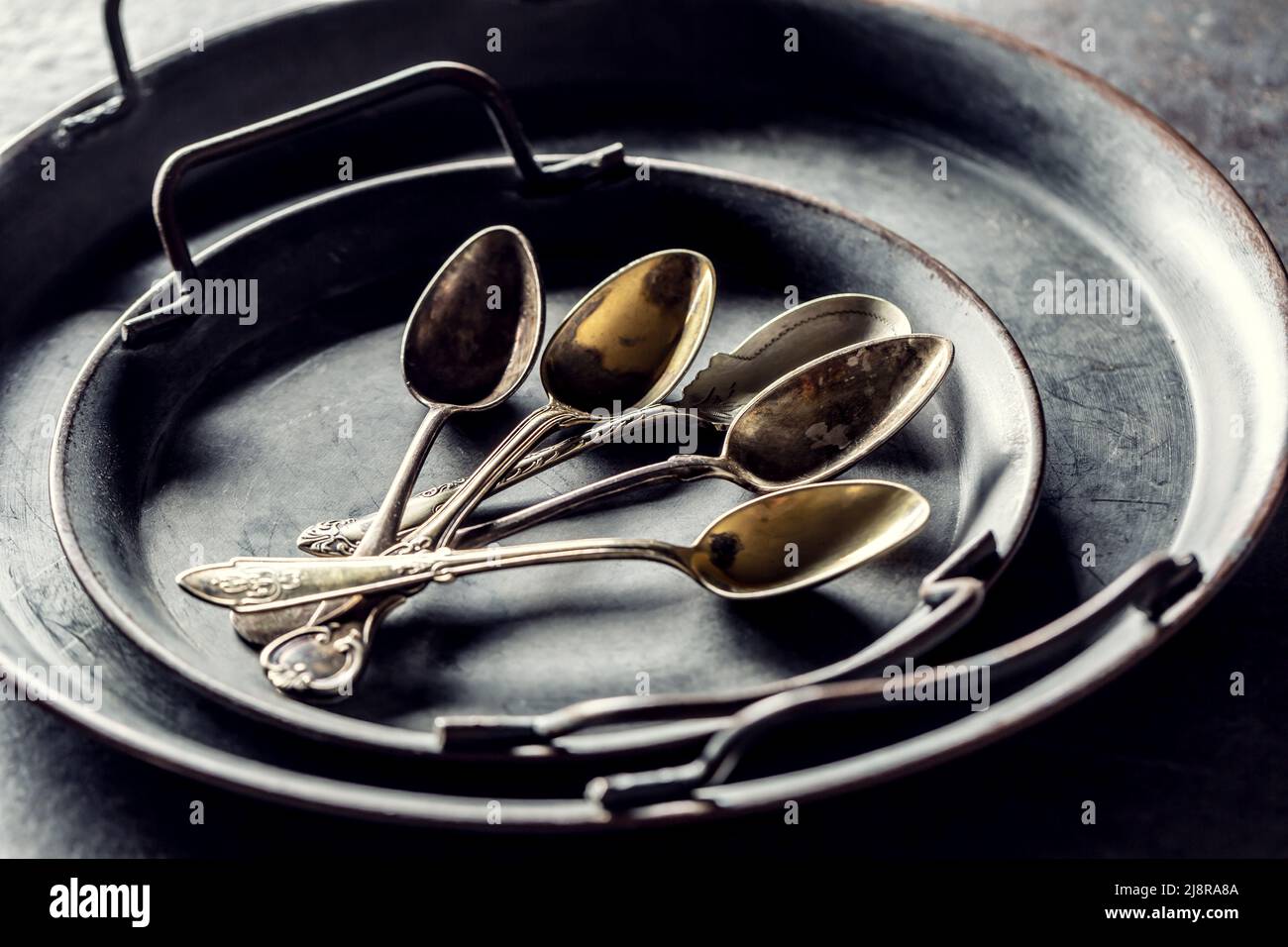 Antike Tabletts mit Löffeln auf einem rustikalen Tisch. Stockfoto