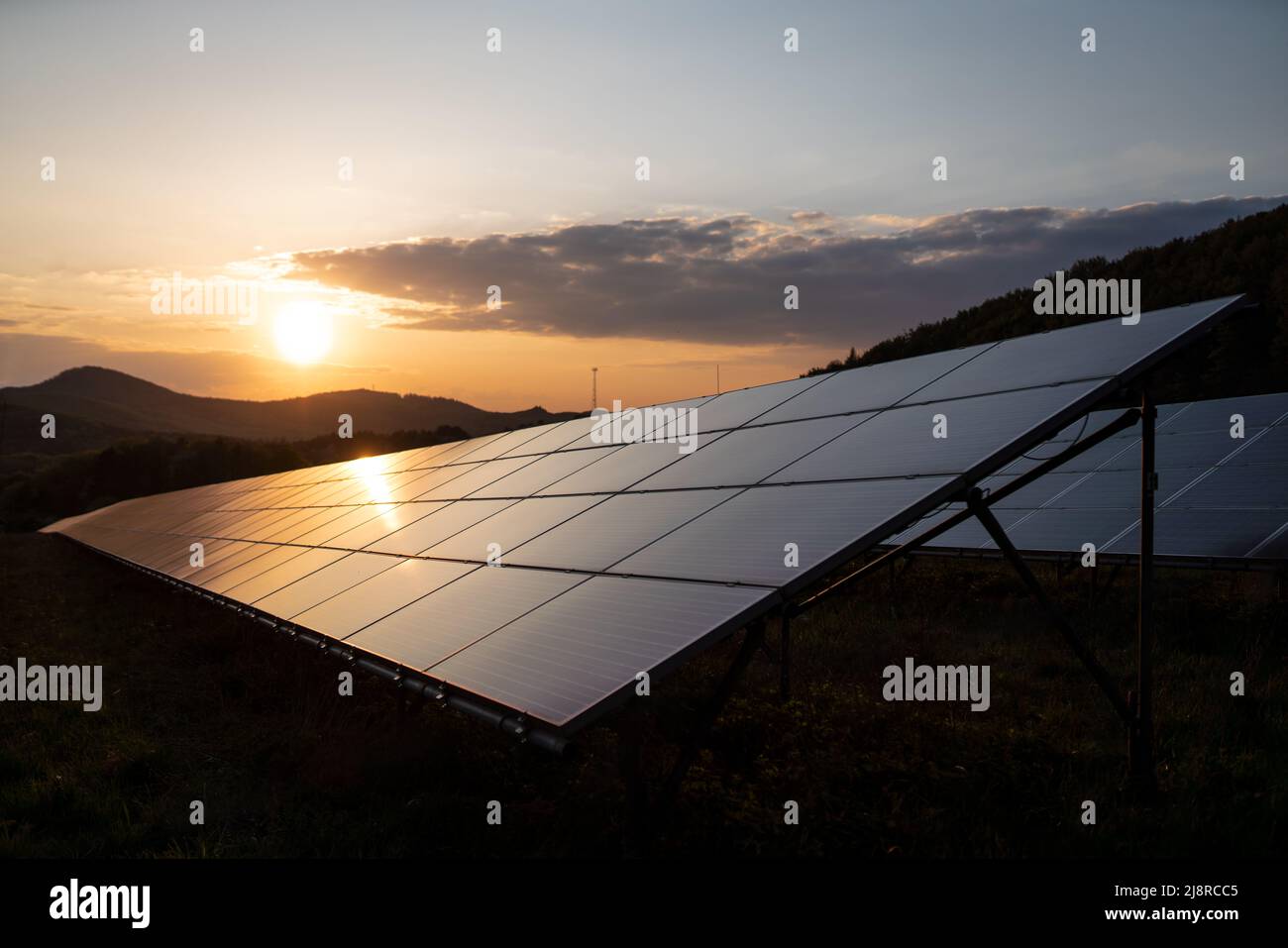 Solarpanel vor Sonnenuntergang Hintergrund. Photovoltaik, alternative Stromquelle. Stockfoto
