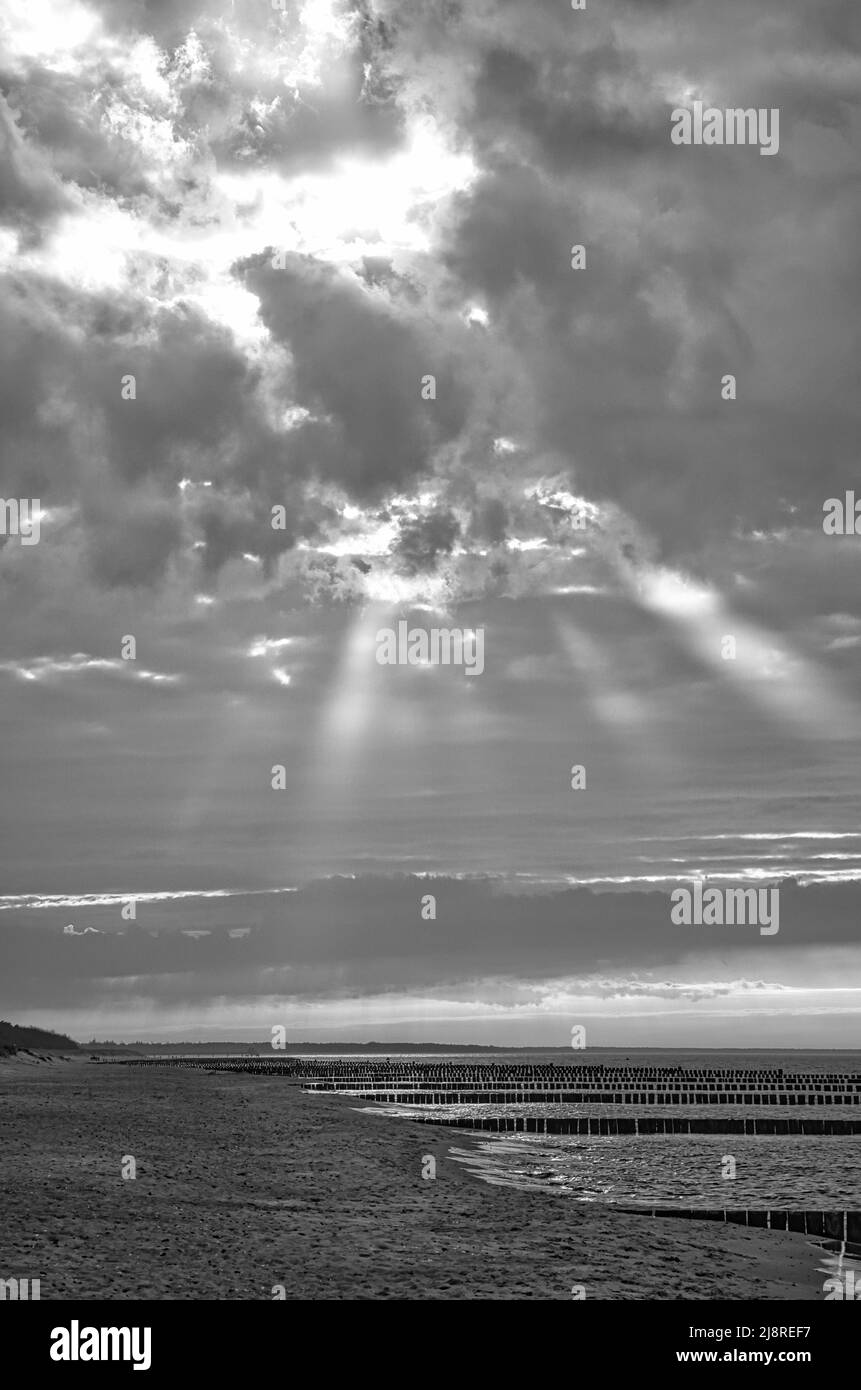 Im Frühjahr Blick über den Strand in Zingst an der Ostsee. Spazieren Sie durch das Meer in Schwarz und Weiß. Sich bewegende Wolken am Himmel Stockfoto