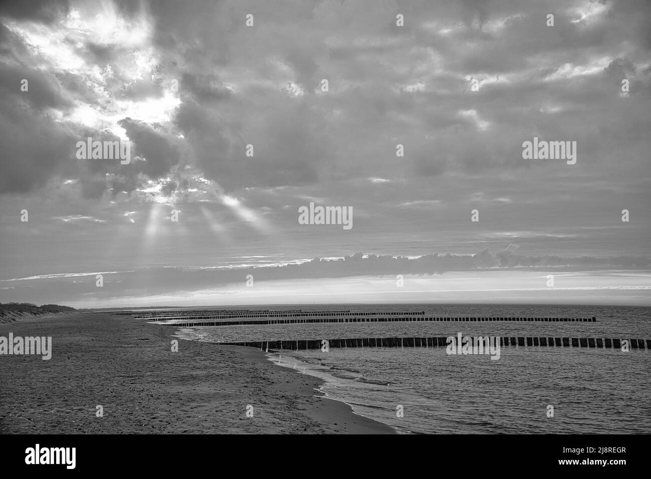 Im Frühjahr Blick über den Strand in Zingst an der Ostsee. Spazieren Sie durch das Meer in Schwarz und Weiß. Sich bewegende Wolken am Himmel Stockfoto