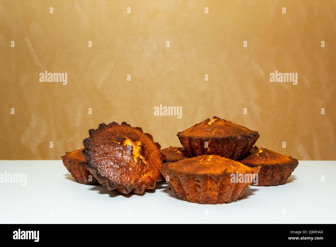 Frisch gebackene Cupcakes auf einem weißen Tisch. Hausmannskost. Köstliches Gebäck. Stockfoto