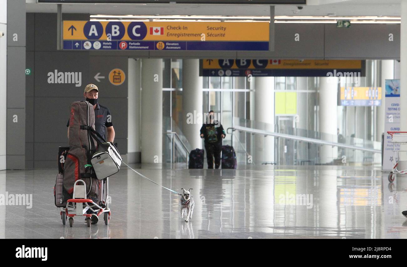 Calgary, Alberta, Kanada - Mai 17 2022: Reisende mit Gepäck und Hund Calgarys International Airport. Stockfoto