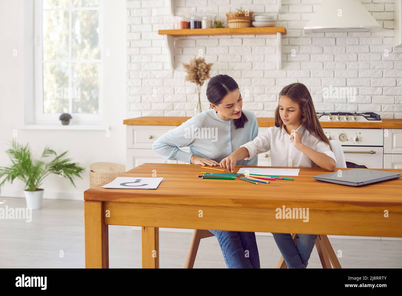 Mutter und Teenager-Tochter entspannen zeichnen zu Hause im Album Stockfoto
