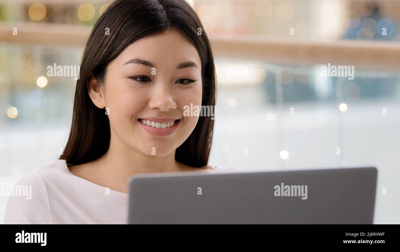 Portrait lächelnd glücklich asiatische weibliche Gesicht Blick auf Laptop Zufriedene Mädchen Frau freiberuflich Chef Arbeiter Manager Eingabe Computer mit Shopping App Serv Stockfoto