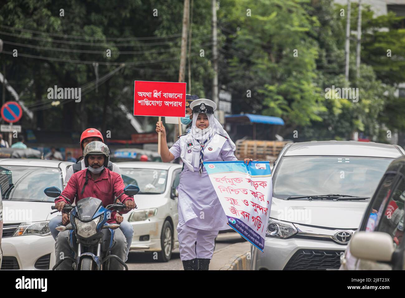 Ein Rover Scout-Mitglied hält während der No Horn-Kampagne in Dhaka ein Plakat und ein Banner im Verkehr. Lärmbelästigung ist in Bangladesch zu einem erheblichen Problem geworden. Das Umweltministerium für Umwelt, Wald und Klimawandel organisierte am 17.. Mai eine „No Horn“-Kampagne und ein mobiles Gericht, um die Lärmbelastung zu reduzieren. Die Kampagne läuft von 11 bis 4 Uhr an den Kreuzungen Gulshan-1, This Campaign & Mobile Court dient der Bewusstseinsentwicklung von Fahrern und Fahrzeugbesitzern. Damit sie die Mängel der Lärmbelästigung erkennen und das Hupen kontrollieren können. (Foto Stockfoto