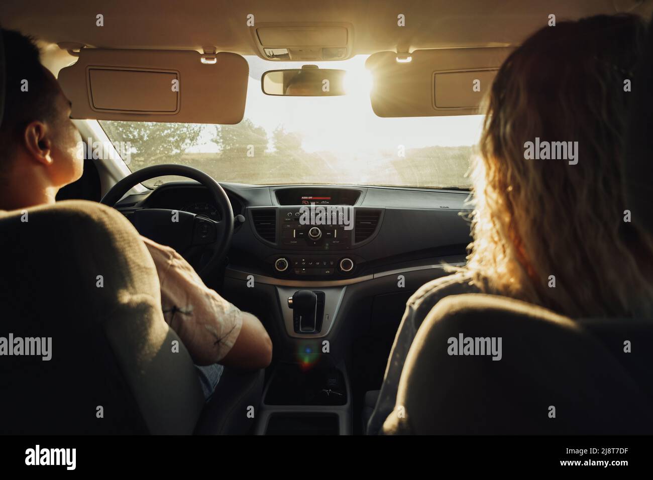 Back View of Woman and man Travelling by Car, Junges Paar auf einem Road Trip at Sunset Stockfoto