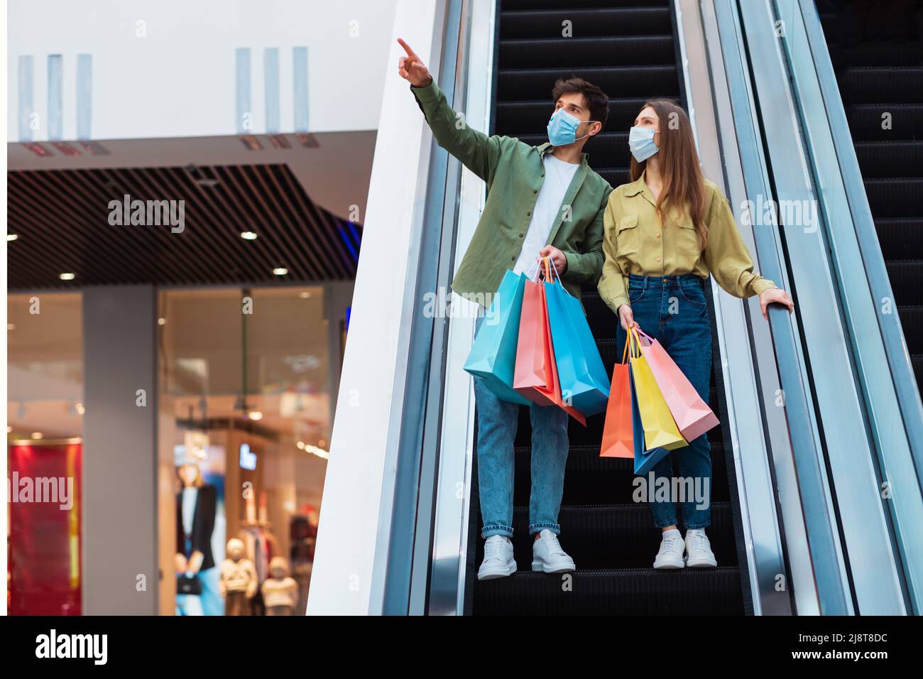 Paar Shopping Zeigen Sie Den Finger In Hypermarket, Tragen Gesichtsmasken Stockfoto