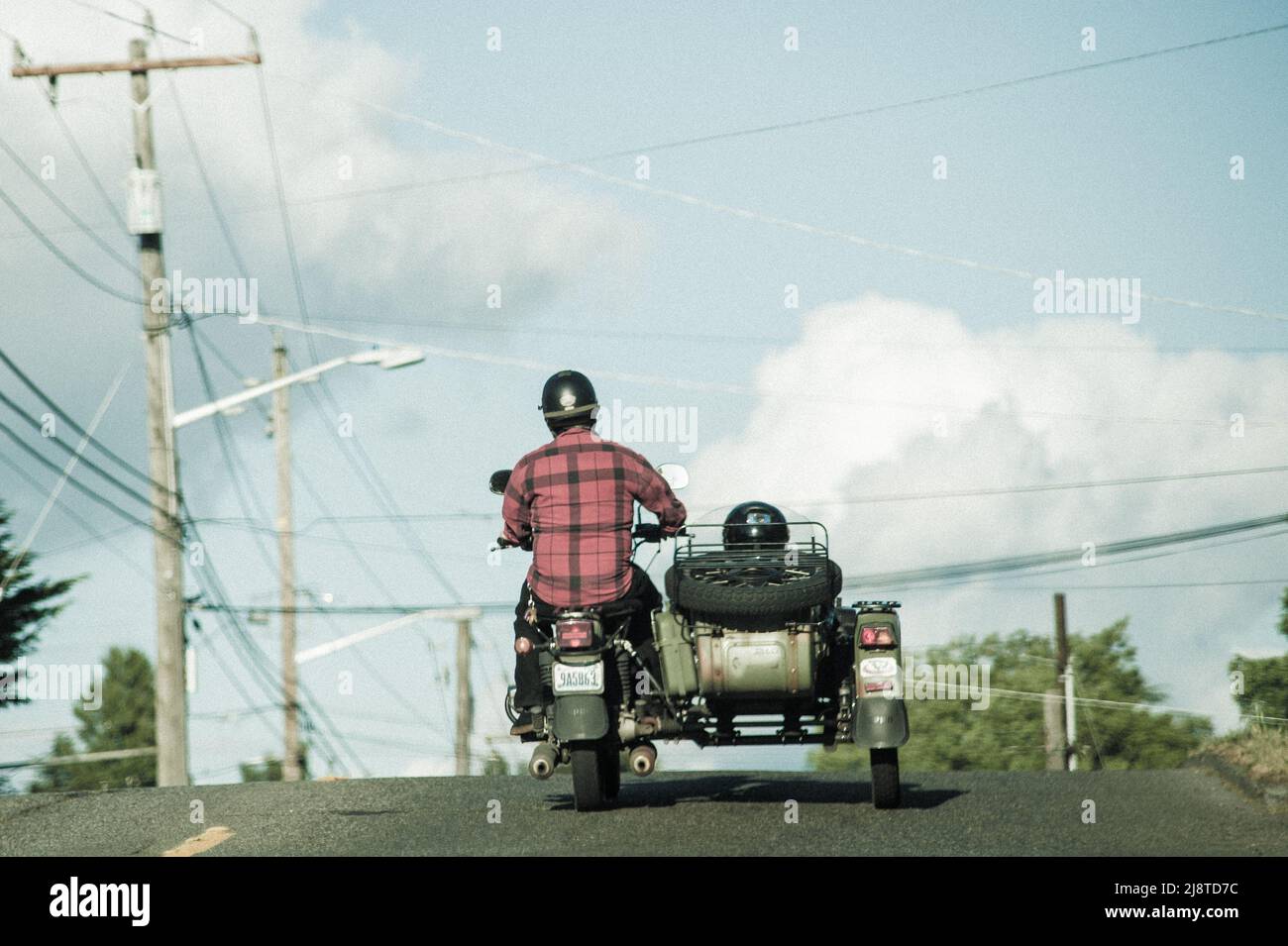Vater und Sohn reiten in Ural Sidecar. Ein dreirädriger russischer Motorrad auf der Straße. Vater und Sohn reiten auf einem coolen Motorrad in Seattle. Stockfoto
