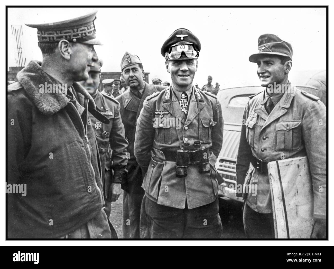 WW2 ERWIN ROMMEL der Wüstenfuchs mit deutschen und italienischen Generälen. General Erwin Rommel , mit Dienstglas 7x50 Fernglas am Flughafen von Tripolis in Nordafrika, um die flaggende Nordafrika-Kampagne unter den Italienern wieder zu beleben. Datum: 1942. Juni Stockfoto