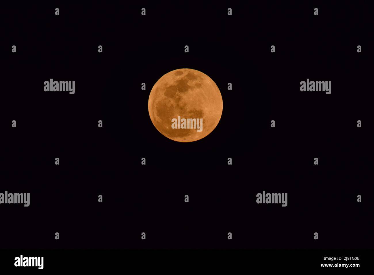 Die frühen Stadien des Super Flower Blood Moon vom 15. Und 16. 2022. Mai, als der Mond hellorange leuchtete. Stockfoto