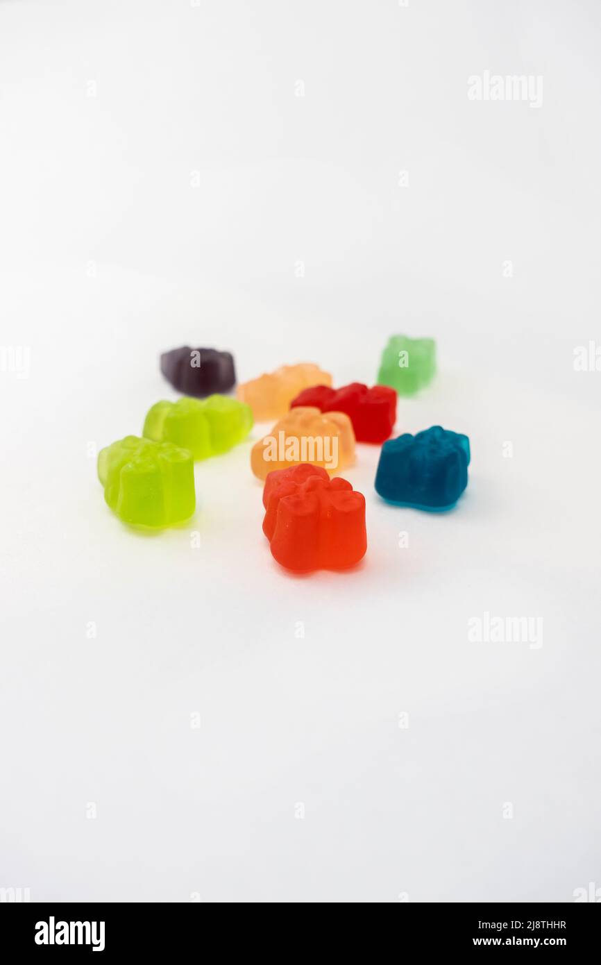 Farbenfrohes Set von CBD-infundiert medizinischen Süßigkeitengummis, die zur Heilung auf einem schlichten weißen Hintergrund verwendet werden Stockfoto