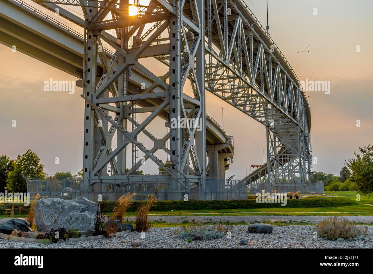Blue Water Bridge zwischen Port Huron, Michigan, USA und Sarnia, Ontario, Kanada, mit Beton- und Stahltraversen bei sanftem Licht bei Sonnenuntergang. Stockfoto