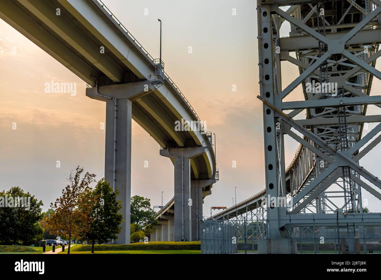 Blue Water Bridge zwischen Port Huron, Michigan, USA und Sarnia, Ontario, Kanada, mit Beton- und Stahltraversen bei sanftem Licht bei Sonnenuntergang. Stockfoto