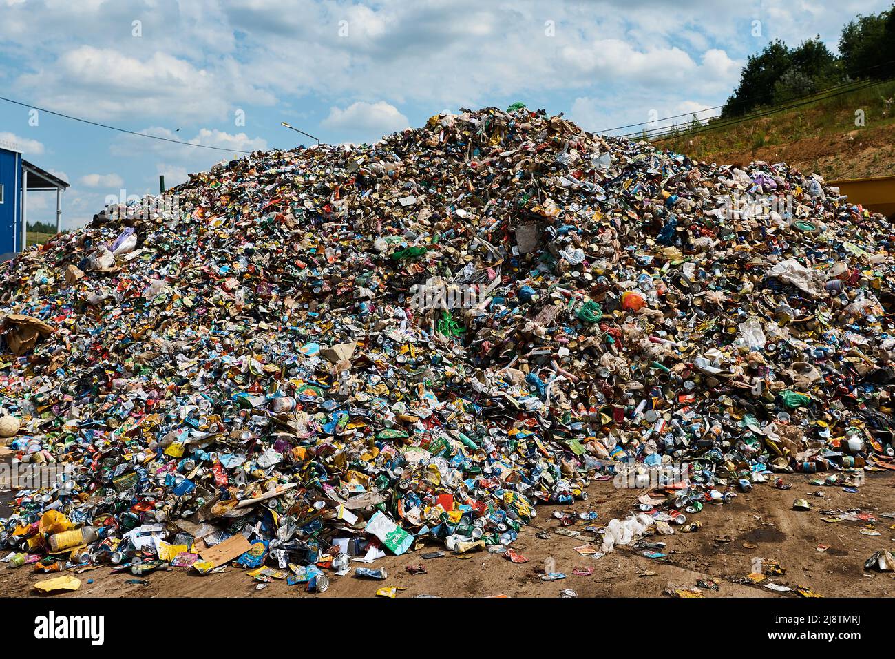 Riesiger Müllhaufen in der Recyclingfabrik unter dem Himmel mit Wolken Stockfoto